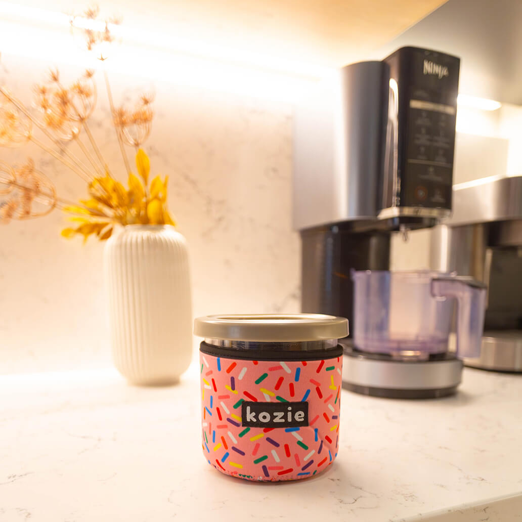 Koozie on kitchen table with Ninja Creami ice cream appliance in background